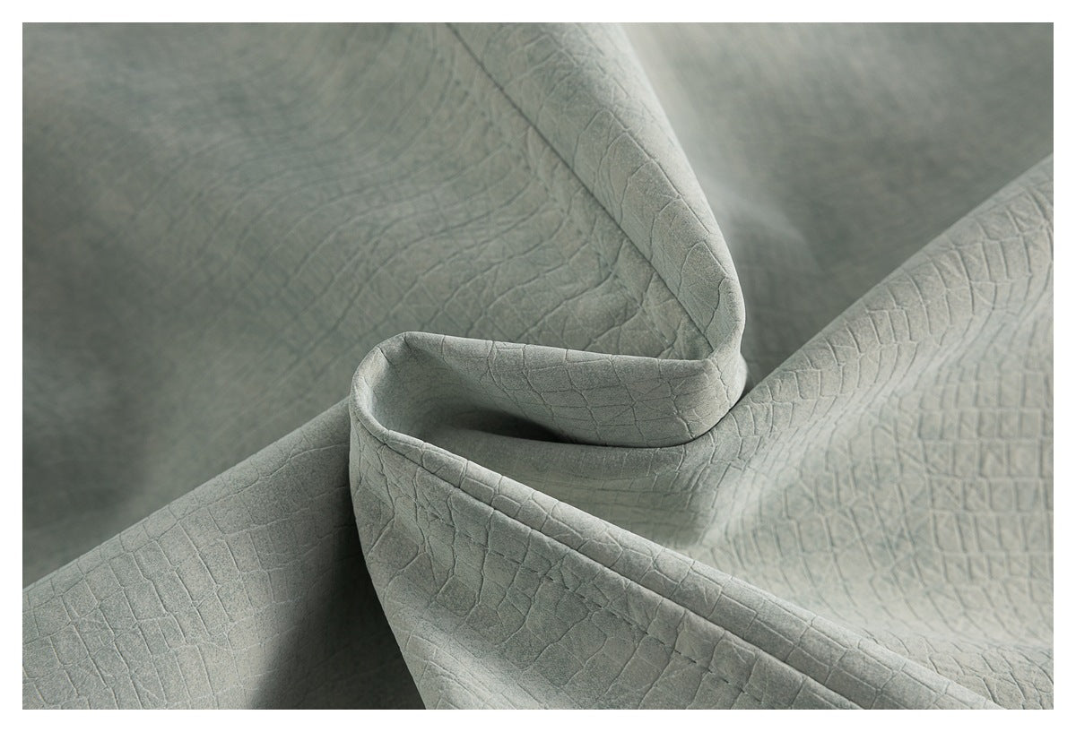 Close-up of folded gray fabric with a raised, irregular grid texture.