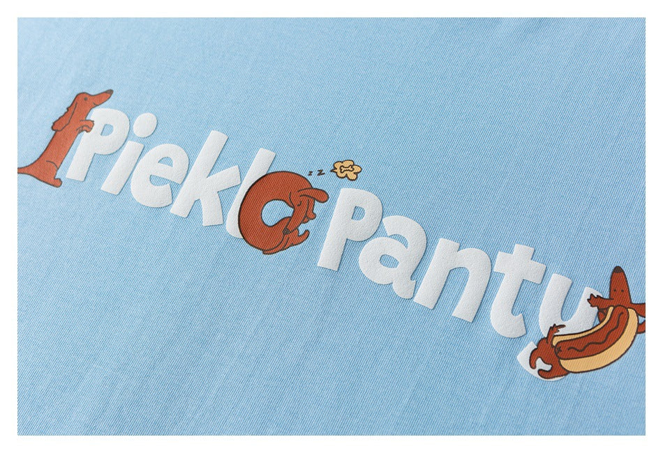 Close-up of the light blue T-shirt's printed chest graphic with large white lettering and cartoon hotdogs.