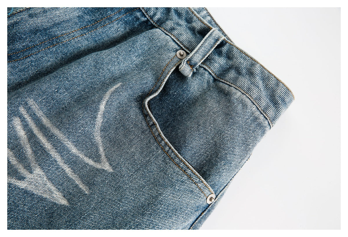 Close-up of washed blue jeans showing the waistband, belt loop, and curved front pocket seam.