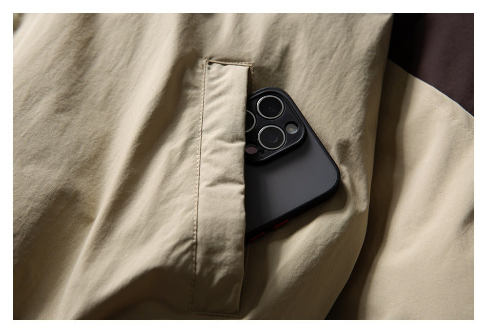 Close-up of a vertical pocket on a beige jacket, with a phone tucked inside.