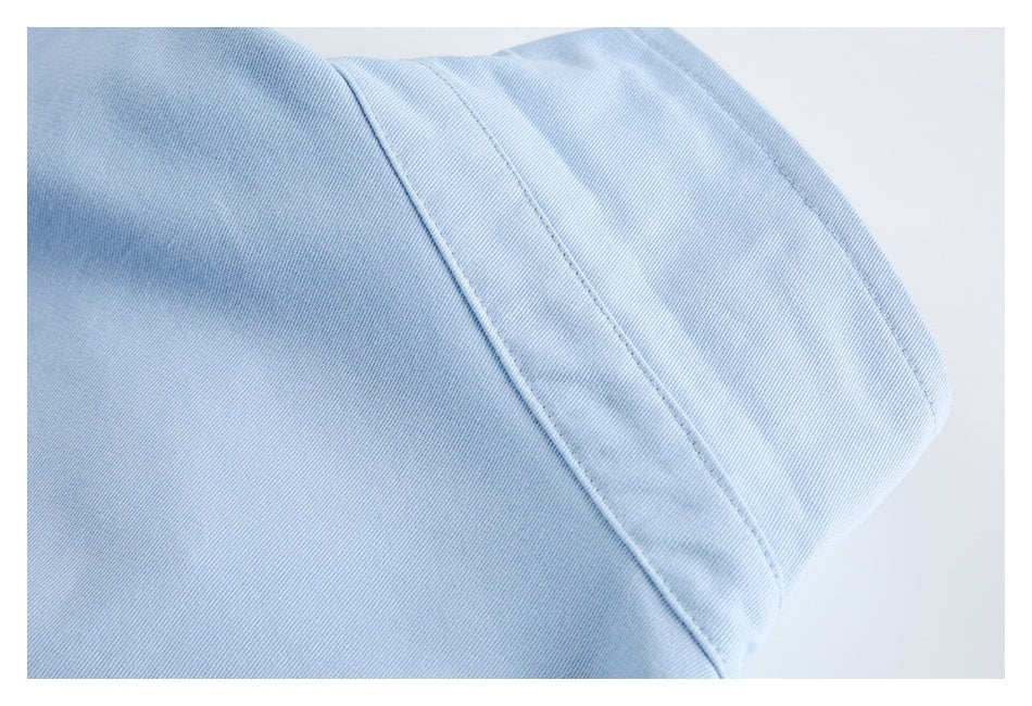 Close-up of a folded light blue garment edge with a stitched seam.