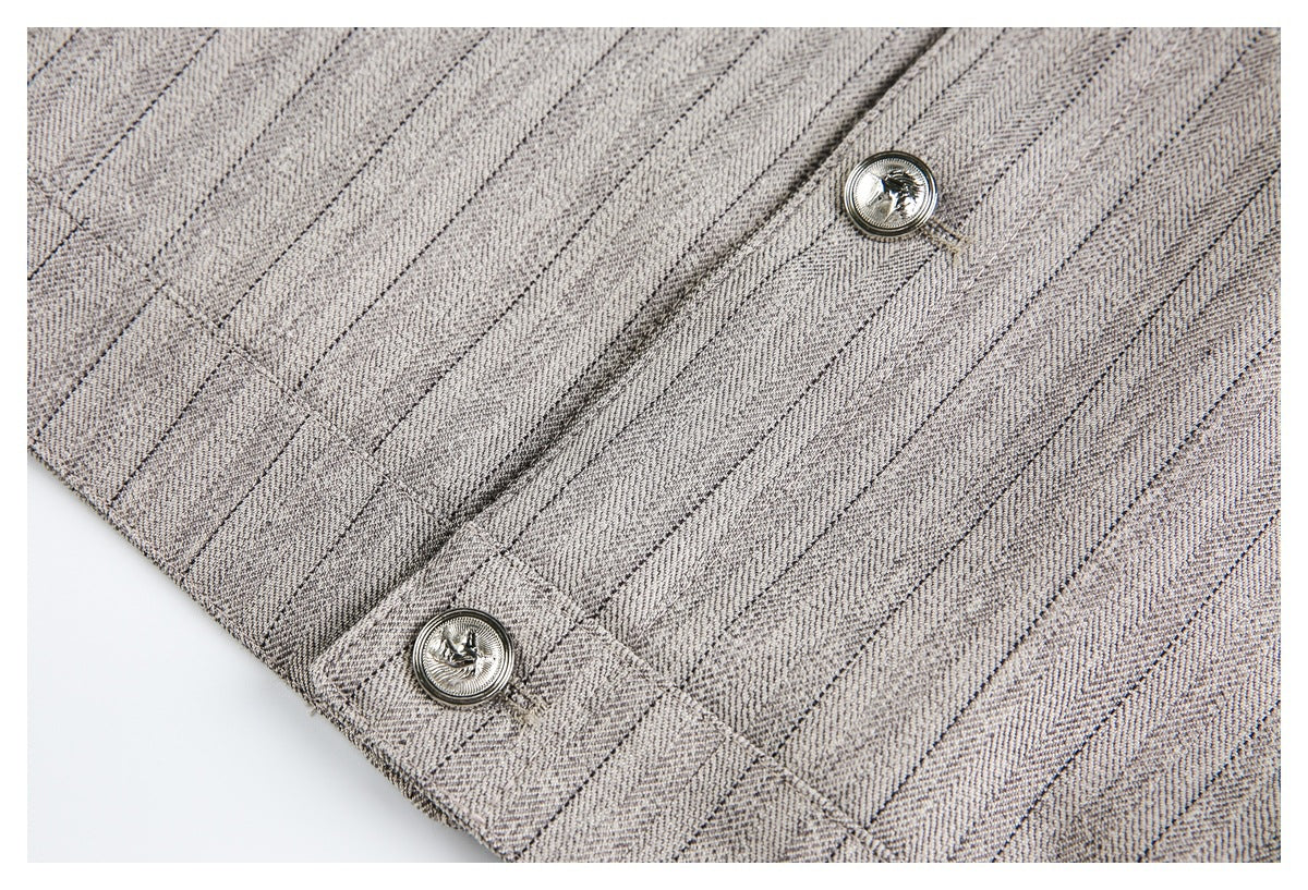 Close-up of gray-beige diagonally patterned fabric with stitched seams and two ornate silver-tone buttons.