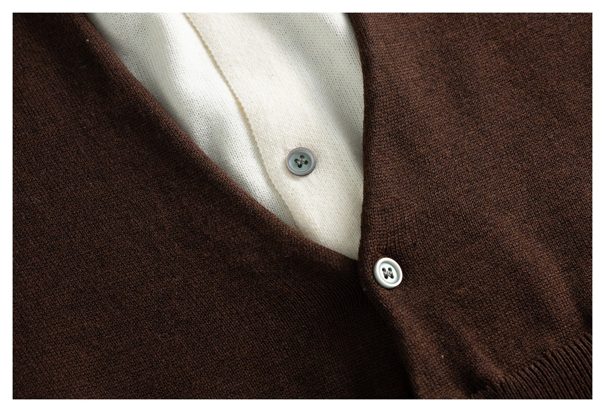 Close-up of the dark brown cardigan front with a button and cream garment visible beneath.
