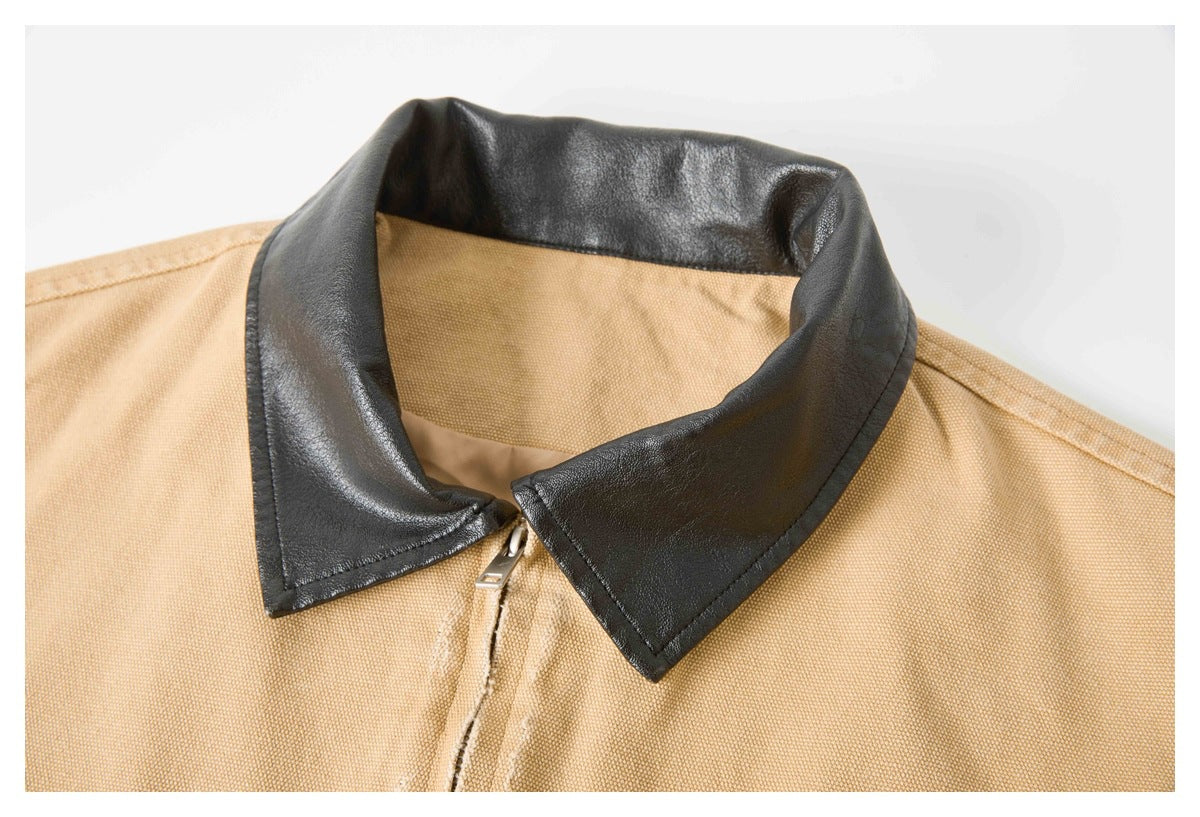 Close-up of the black pointed collar and zipper on a tan jacket.