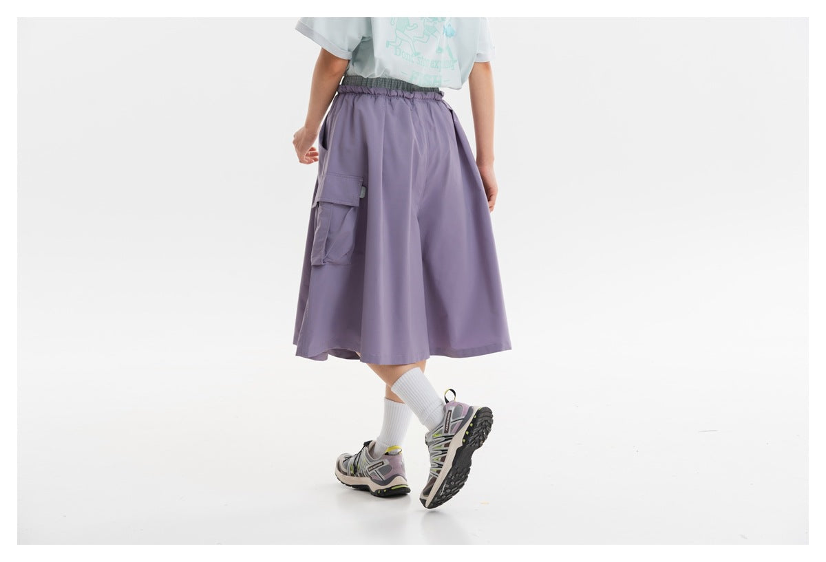 Rear view of a model wearing a lavender cargo skirt with an elastic waist and side cargo pocket.