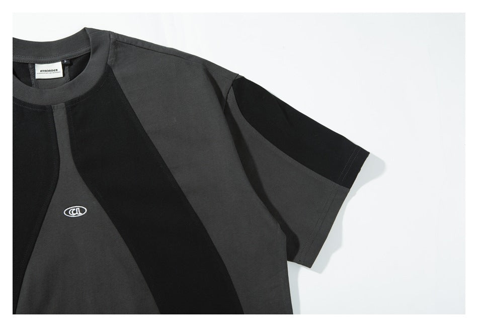 Close view of the T-shirt's black-and-charcoal color-block short sleeve and chest panels.