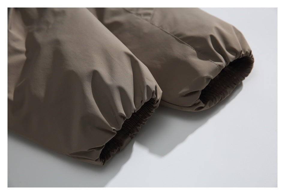Close-up of two taupe garment cuffs with gathered elastic openings and stitched seams.