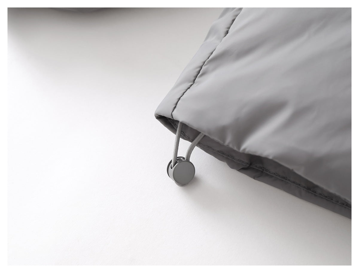 Close-up of a gray jacket hem with an elastic drawcord and round adjustment toggle.