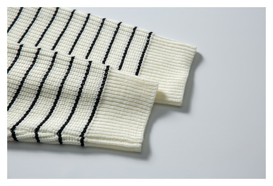Close-up of ivory sleeves with narrow black stripes and wide ribbed cuffs.