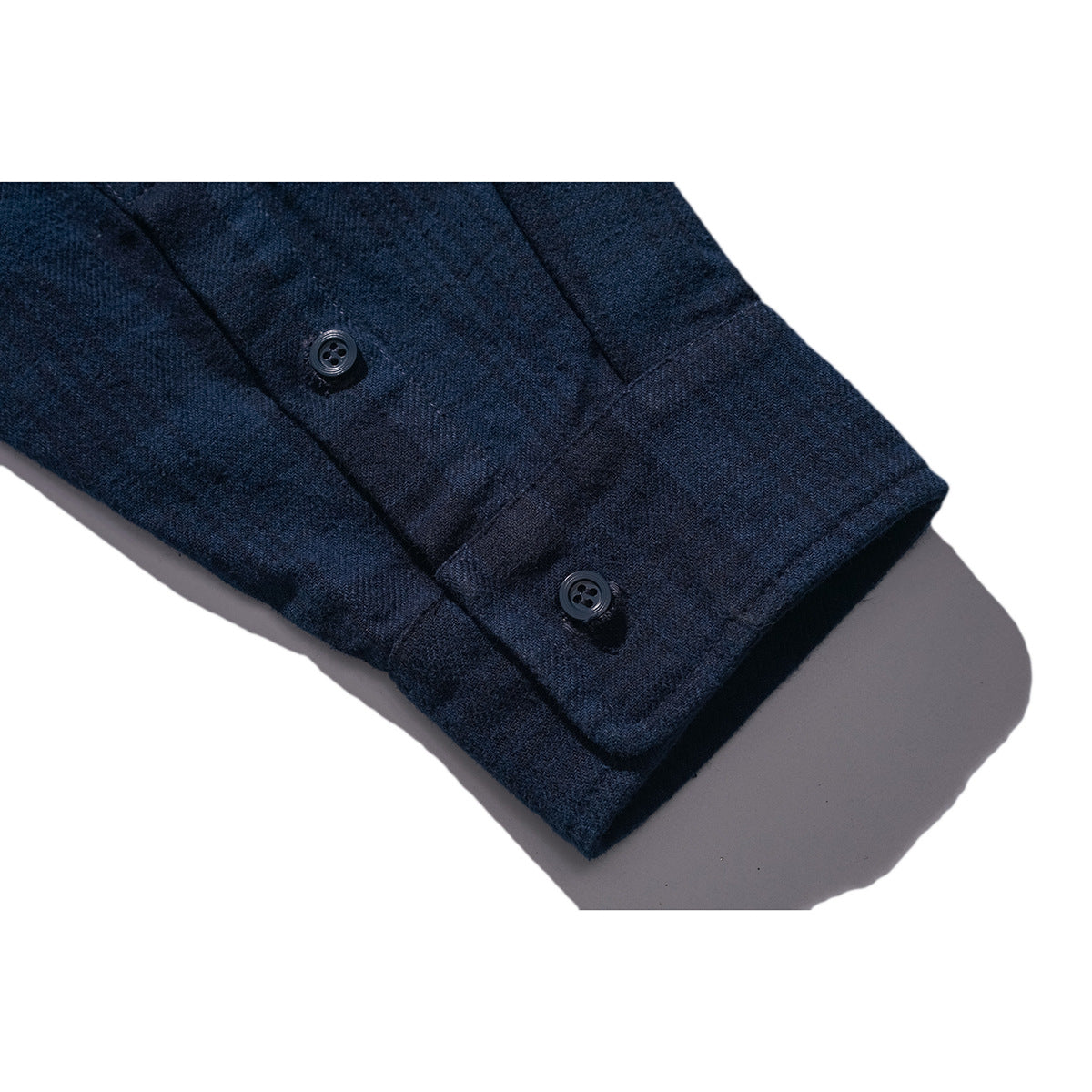 Close-up of a dark navy shirt sleeve cuff with two buttons.