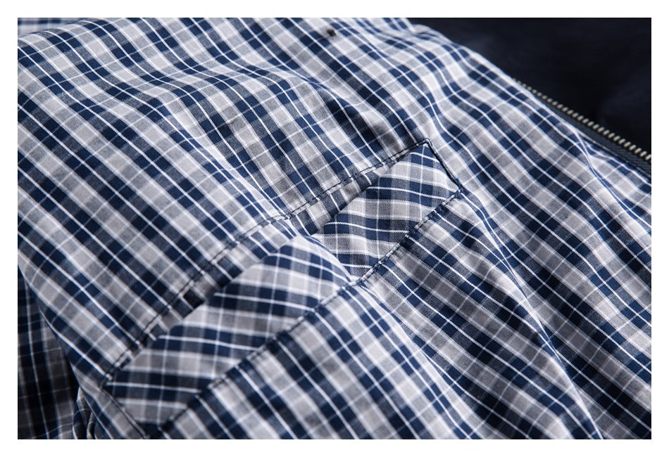 Close-up of navy, gray and white checked jacket lining and its stitched seam.