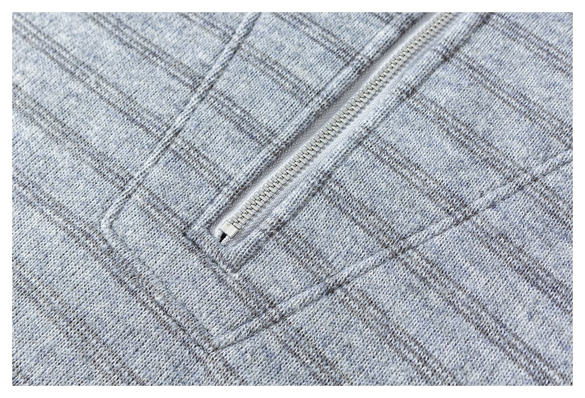 Close-up of a silver zipper set into a gray heathered knit garment.