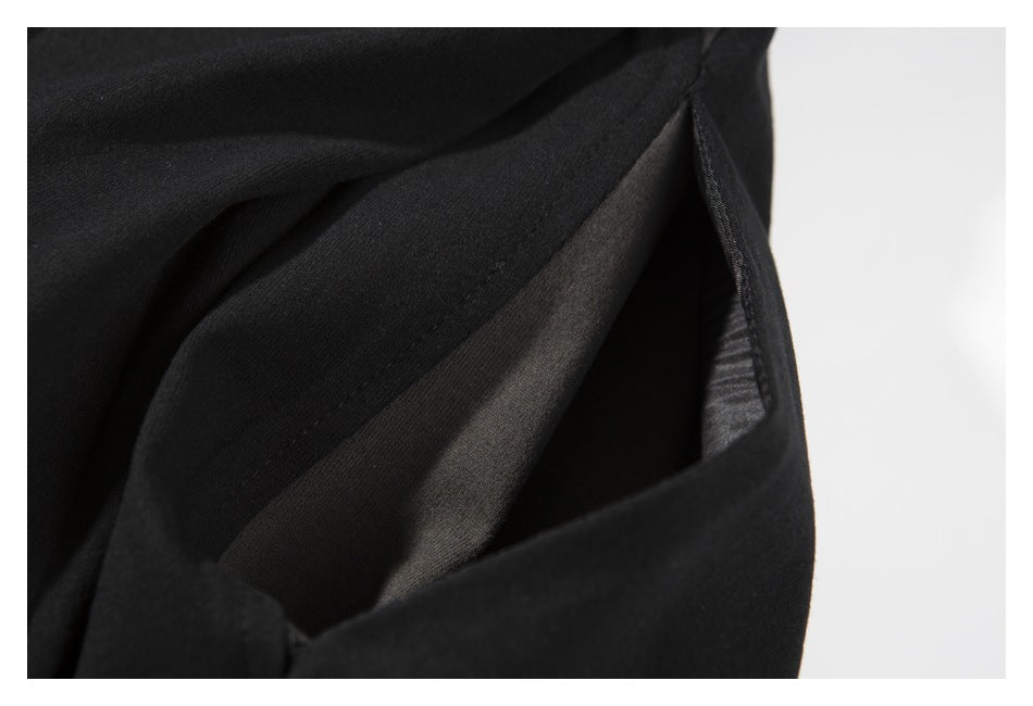 Close-up of a dark garment opening with visible layered fabric and stitching.