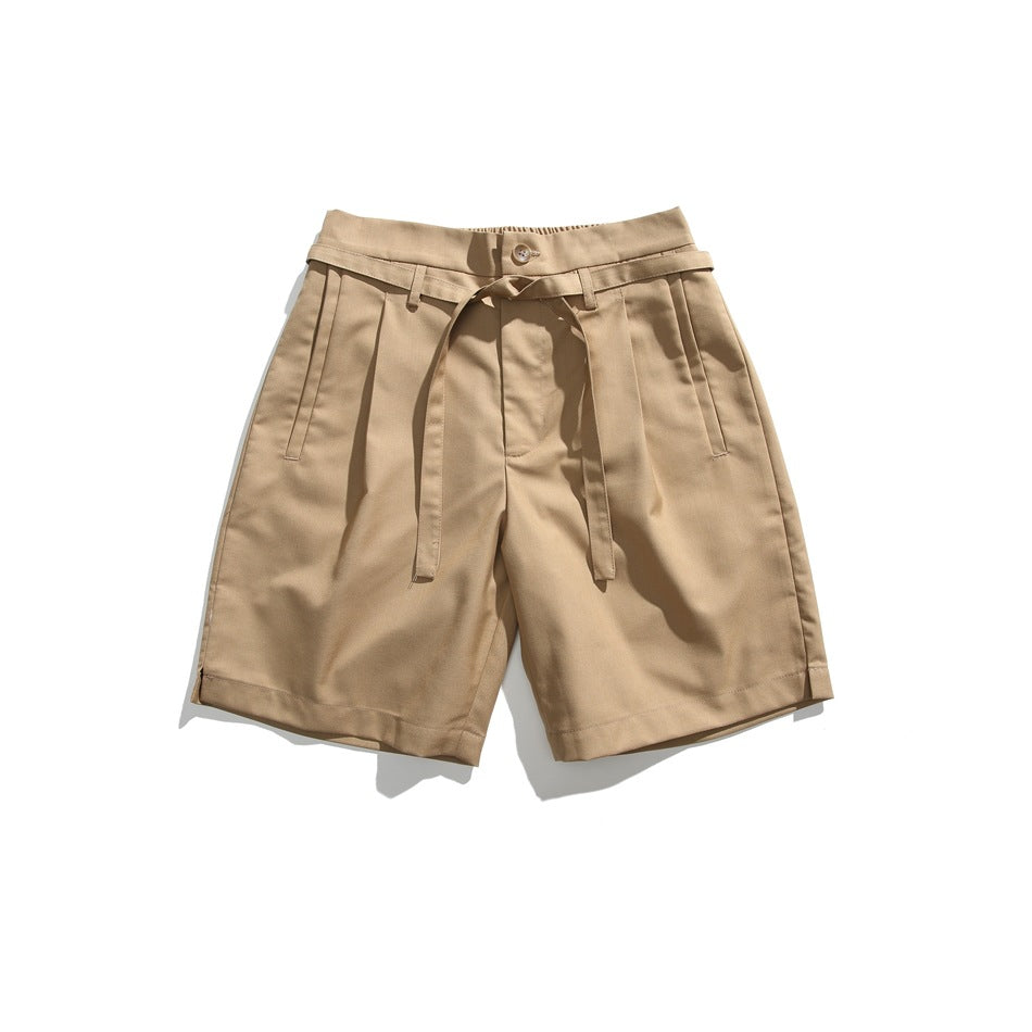 Khaki pleated knee-length shorts with button, tie belt and slanted front pockets, flat lay