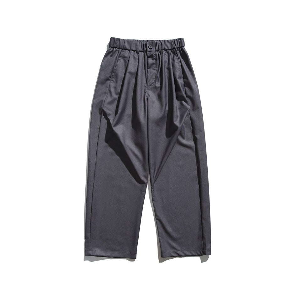 Gray wide-leg trousers with elastic waistband, front button and pleats, flat lay front view