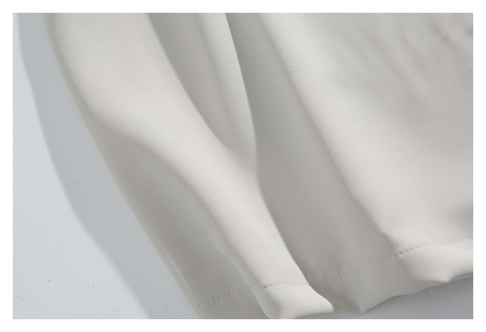 Close-up of the ivory shirt fabric and stitched hem.