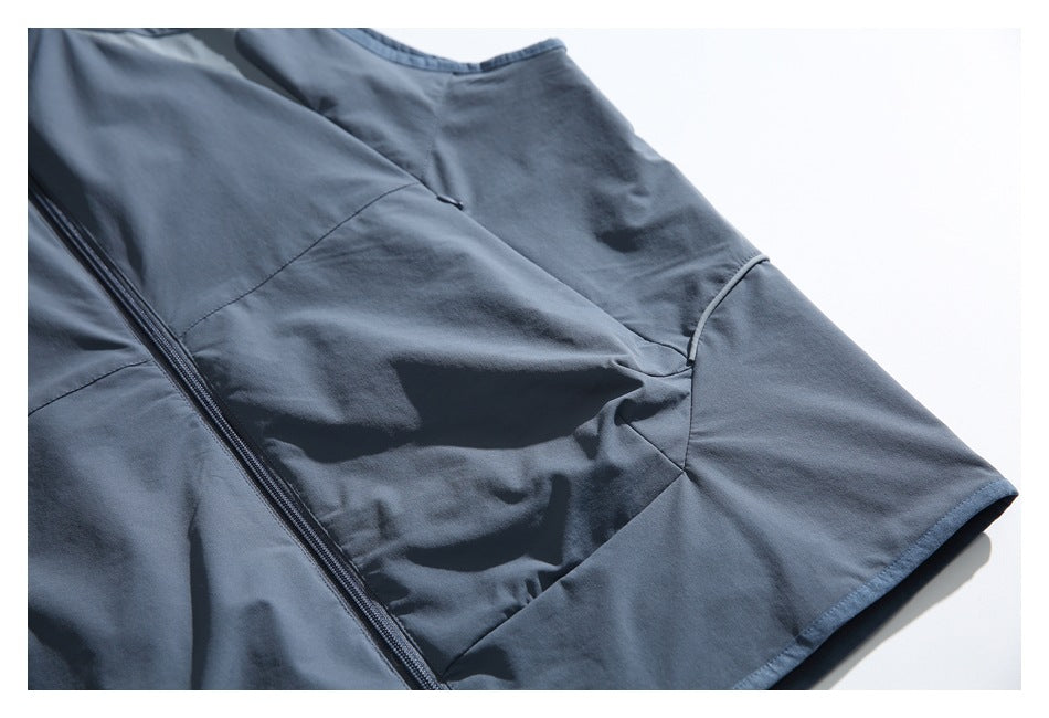 Close-up of a blue-gray garment with a diagonal zipper and curved panel seams.
