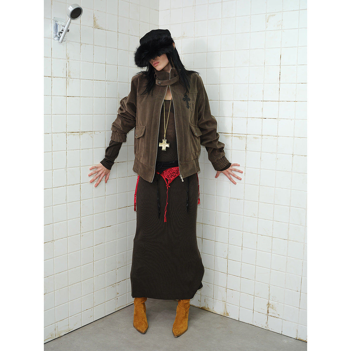 Front view of a model wearing a dark brown zip jacket with flap pockets and a high collar.