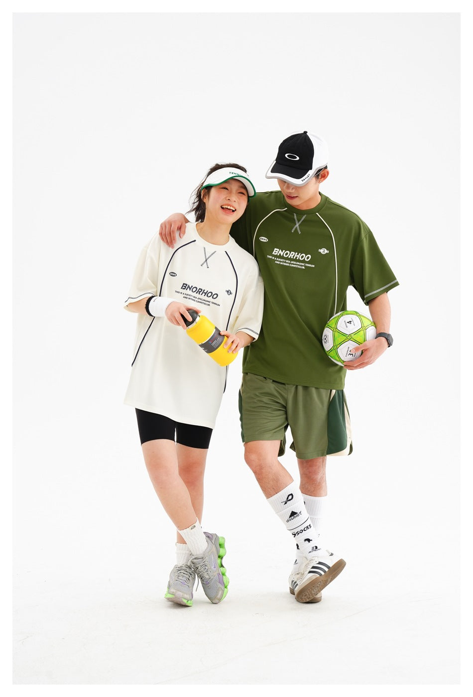 Two models wearing sports T-shirts: one white with dark piping, the other olive green with white piping.
