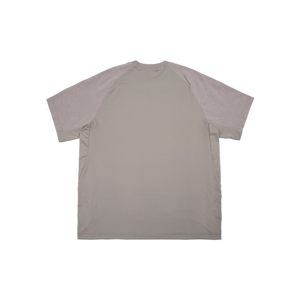Back view of a taupe-gray short-sleeve raglan shirt with muted mauve sleeves and contrasting side panels.