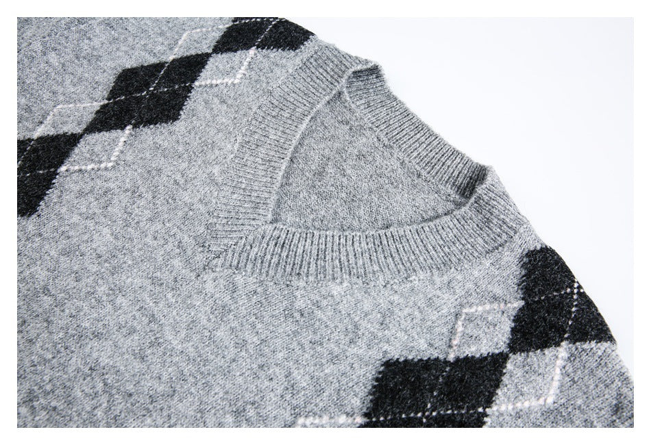 Close-up of a gray marled sweater's ribbed V-neck and black-and-white argyle shoulder pattern.
