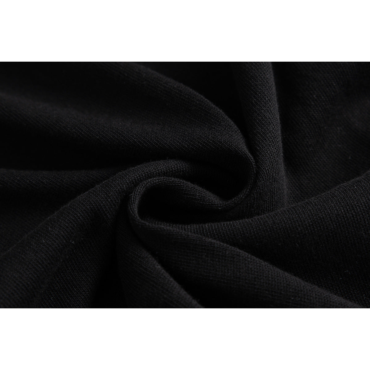 Close-up of black fabric gathered to show its knit texture.