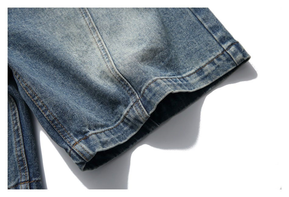 Close-up of a blue denim shorts leg hem with faded wash and visible stitching.