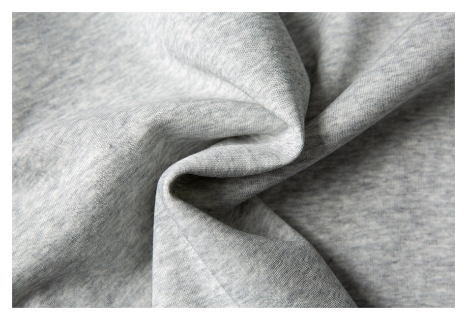 Close-up of light gray heathered knit fabric draped into soft folds.