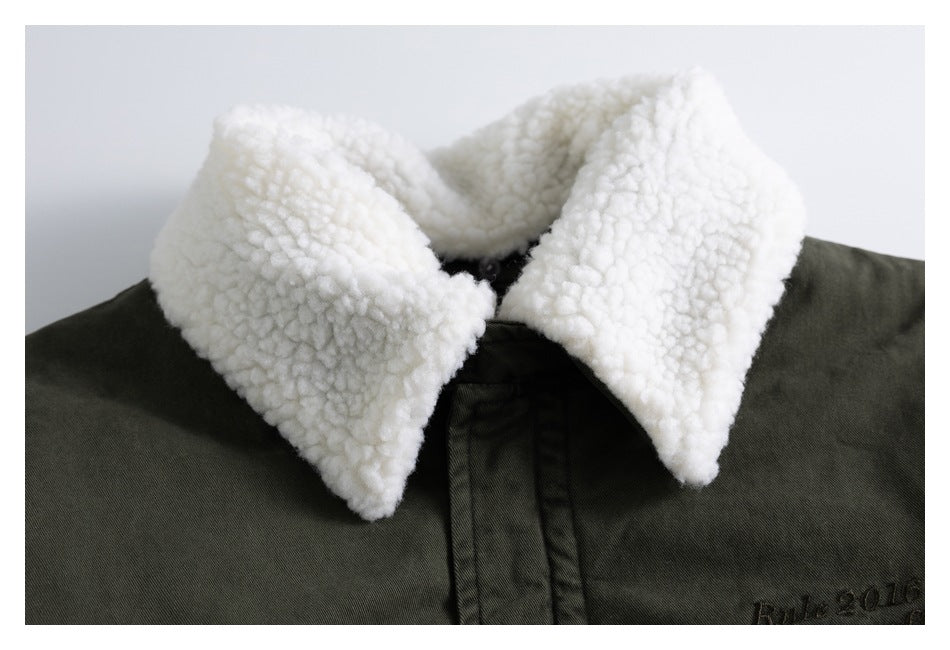 Close-up of an olive jacket's thick white sherpa collar and dark embroidered lettering.