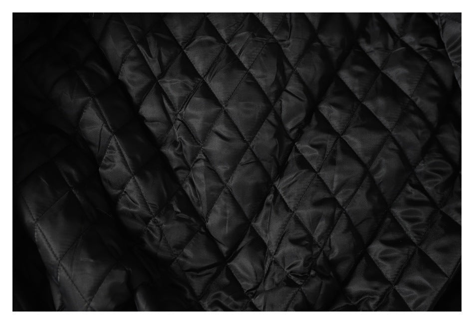 Close-up of black diamond-quilted lining with stitched seams.