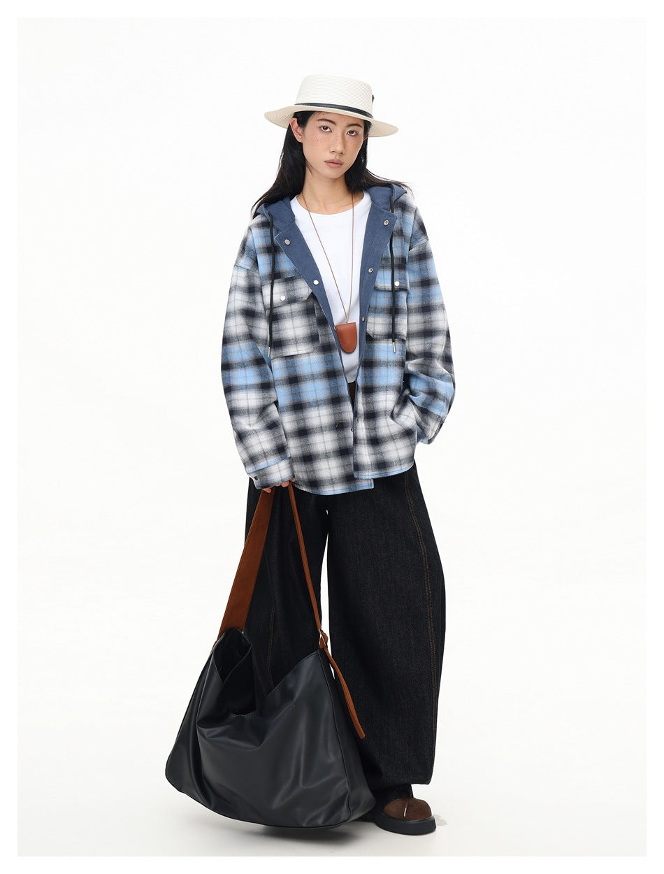 Model wearing the blue plaid hooded jacket open over a white tee with black wide-leg jeans, a straw hat and a black bag