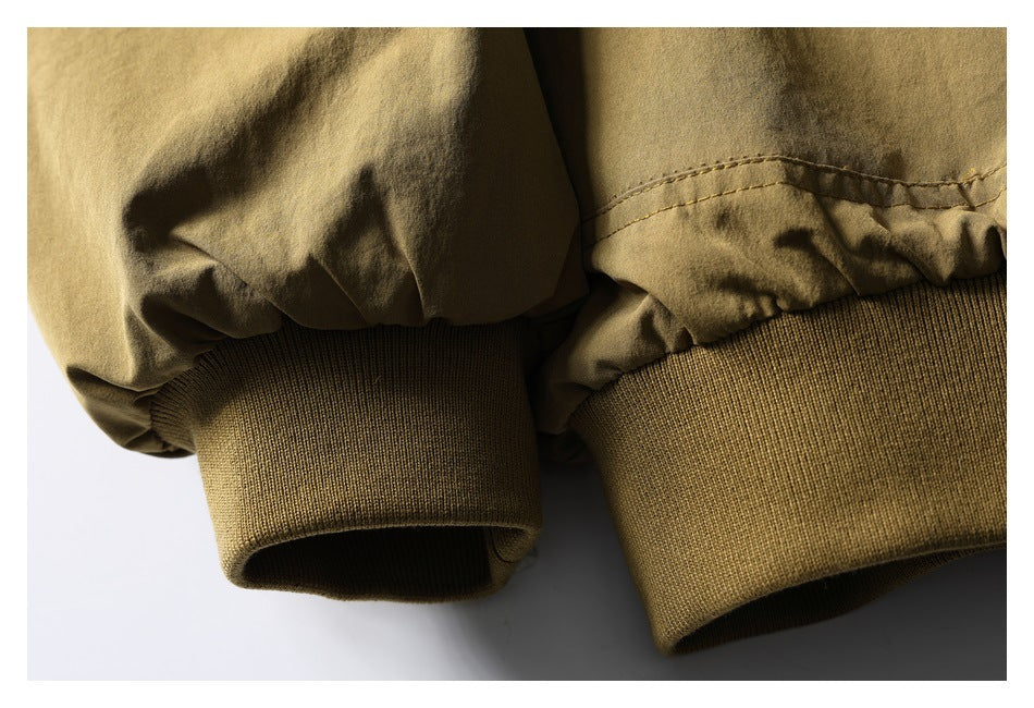 Close-up of tan olive jacket sleeves ending in wide ribbed cuffs.