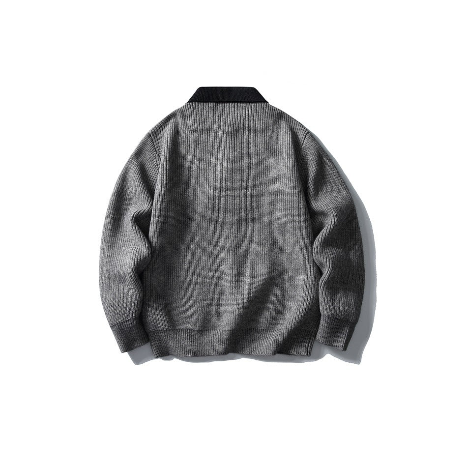 Back view of a gray ribbed sweater with a black collar, sleeves, and hem.