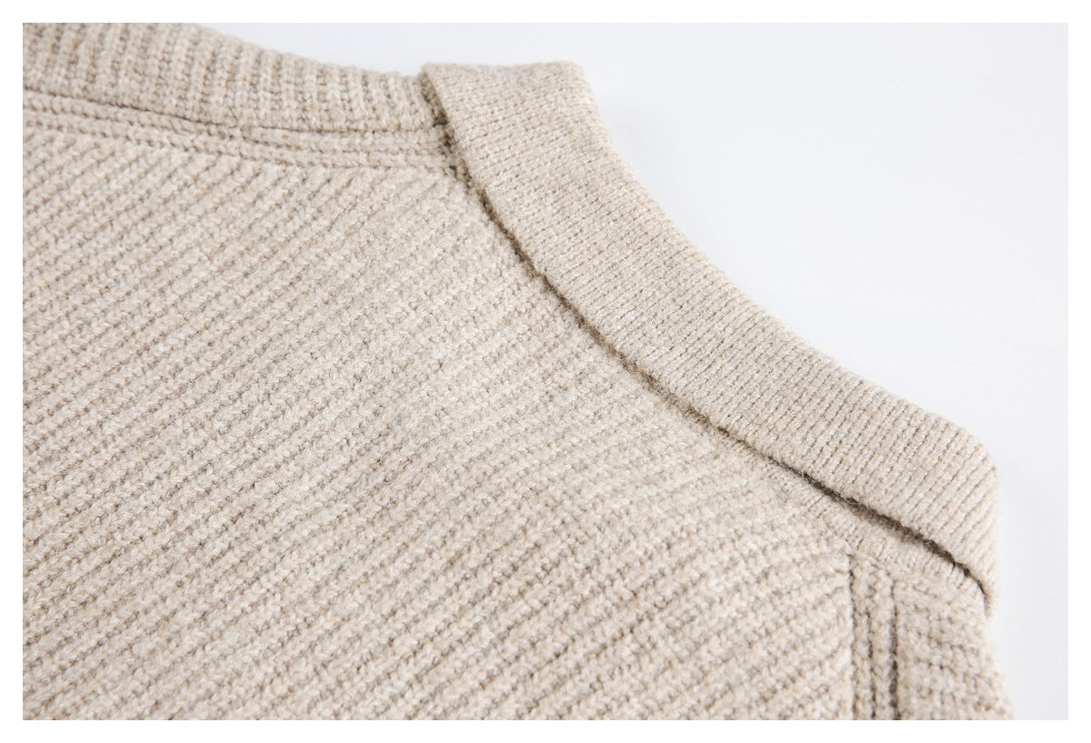 Close-up of a beige knit garment showing a wide ribbed band and joining seam.