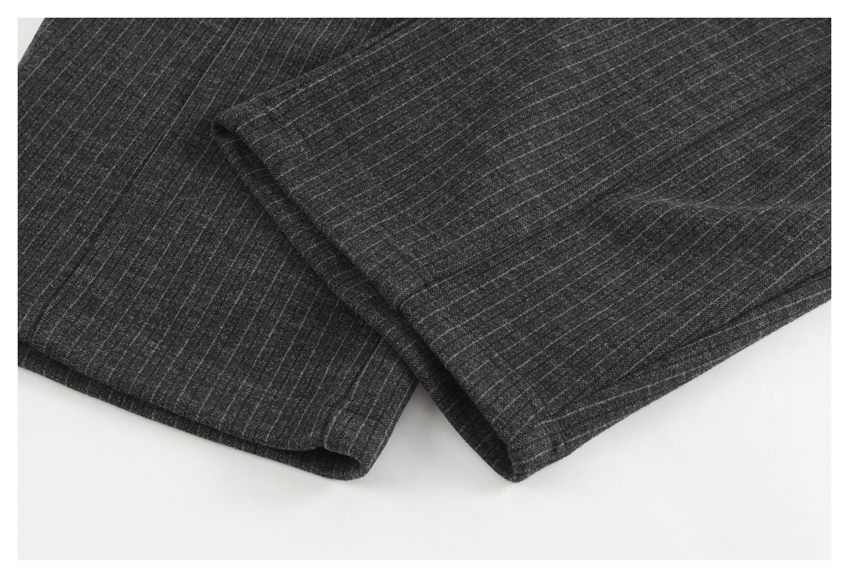 Close-up of the charcoal pinstripe trouser legs and stitched hems.