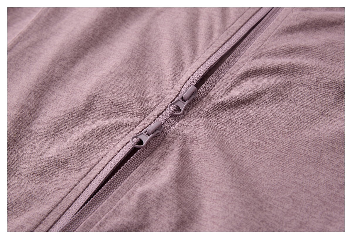 Close-up of a mauve heather garment with a diagonal two-way zipper and ring-shaped pulls.