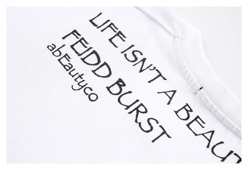 Close-up of black English lettering printed on white fabric beside the garment's ribbed neckline.