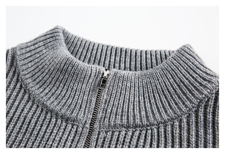 Close-up of a gray rib-knit sweater collar with a short metal zipper.