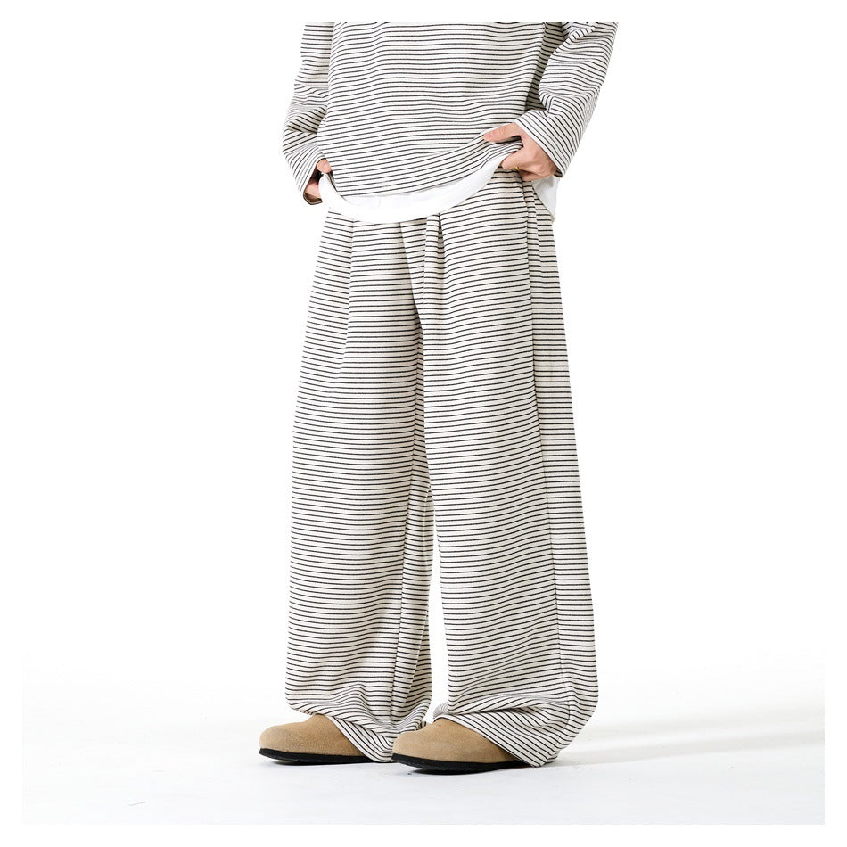 Front view of a model wearing cream wide-leg pants with thin dark stripes and a matching top.