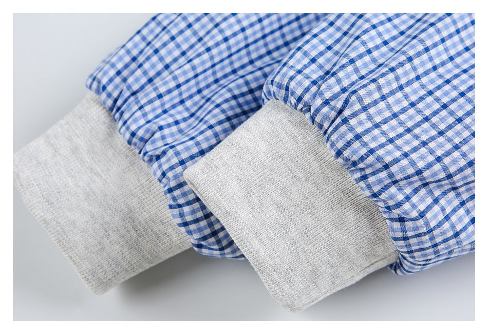 Close-up of light gray ribbed cuffs against blue-and-white gingham sleeves.