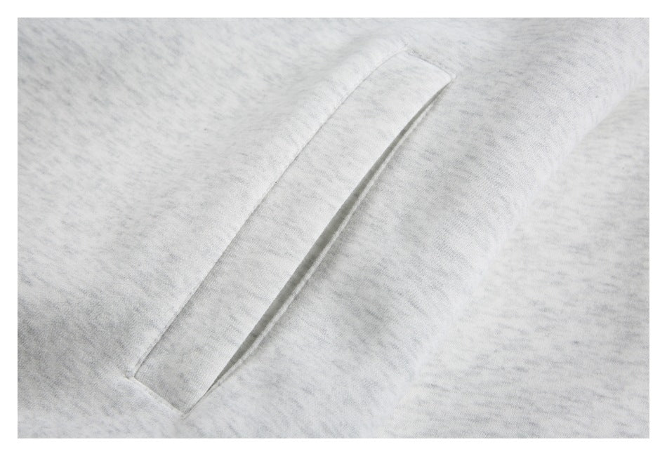 Close-up of a slanted welt pocket on the light gray top.