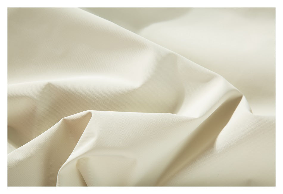 Close-up of ivory fabric with a fine texture and deep folds.