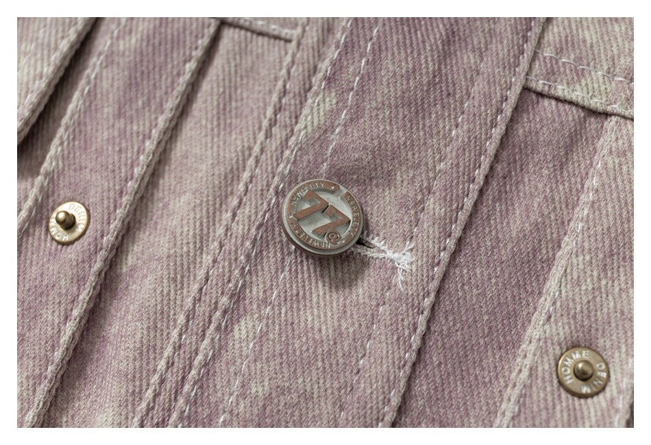 Close-up of a metal logo button and snap fasteners on the jacket's mauve washed fabric.