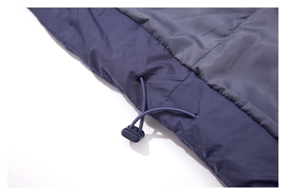 Close-up of a slate-blue garment hem with an adjustable elastic drawcord and toggle.