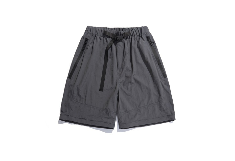 Charcoal gray shorts with an elastic waistband, black adjustable belt strap, and angled zip pockets, shown from the front.