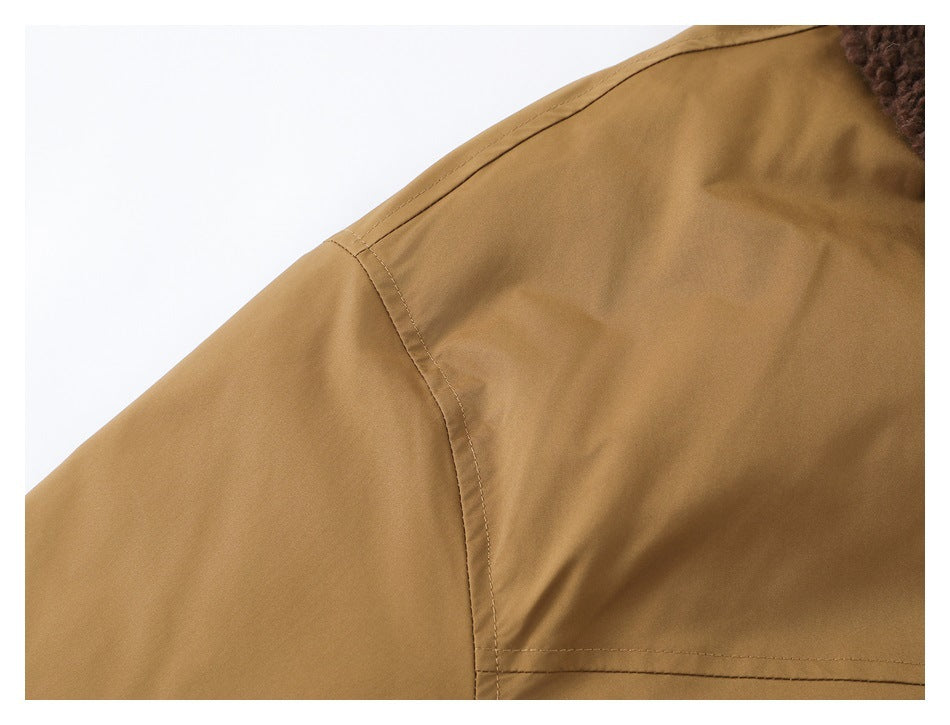 Close-up of the tan jacket's shoulder seam and upper-back stitching.