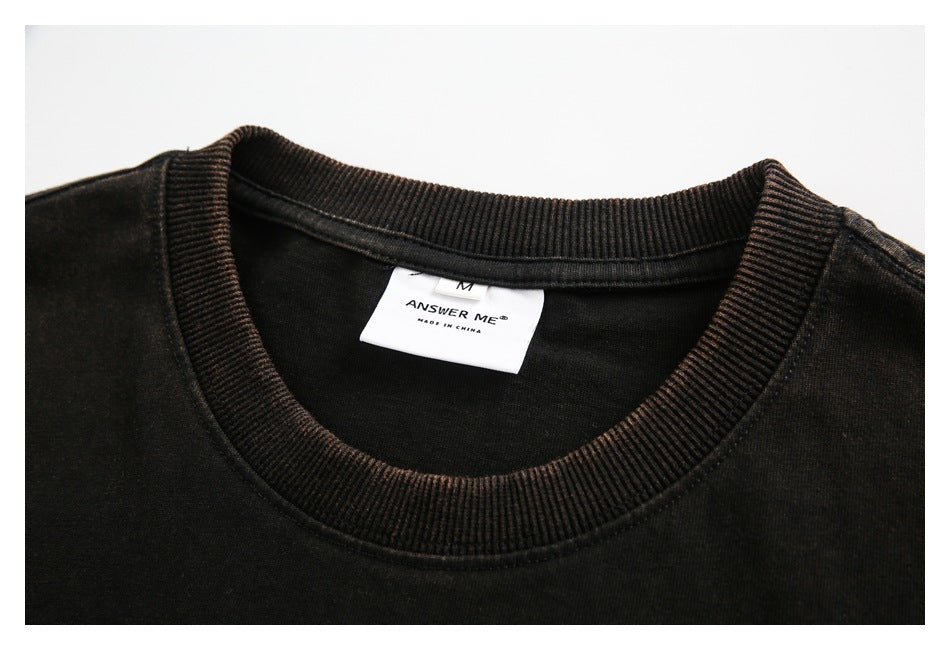 Close-up of a black T-shirt's ribbed crew neck and sewn-in white label.