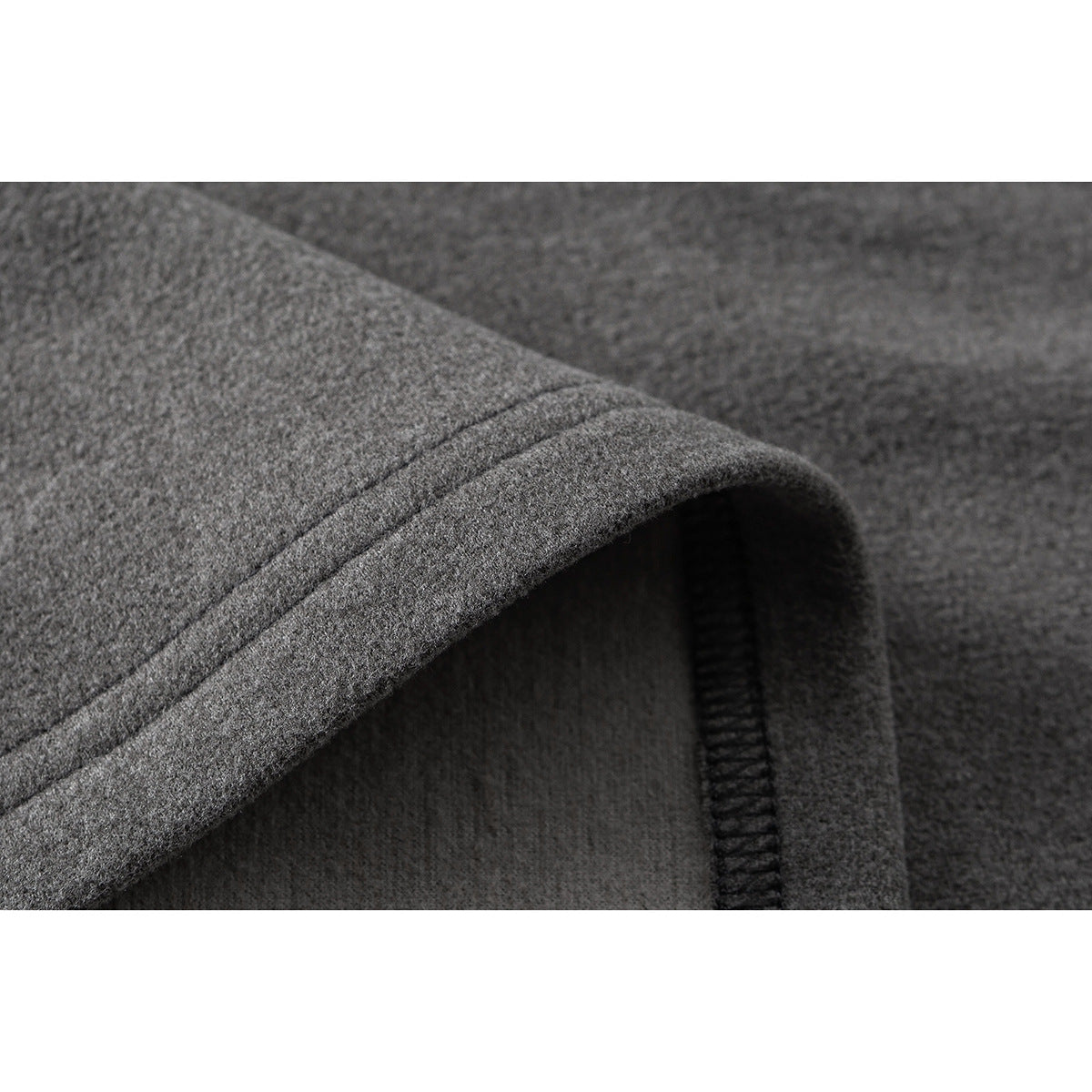 Close-up of a gray shirt's folded hem and interior seam stitching.