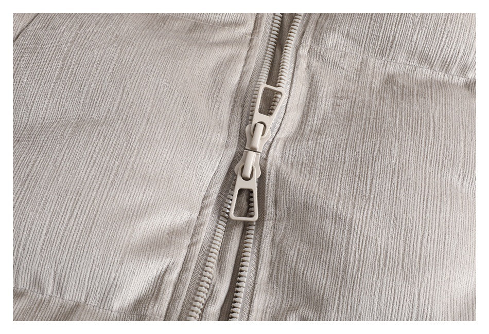 Close-up of the light taupe jacket's double zipper pulls and textured fabric.