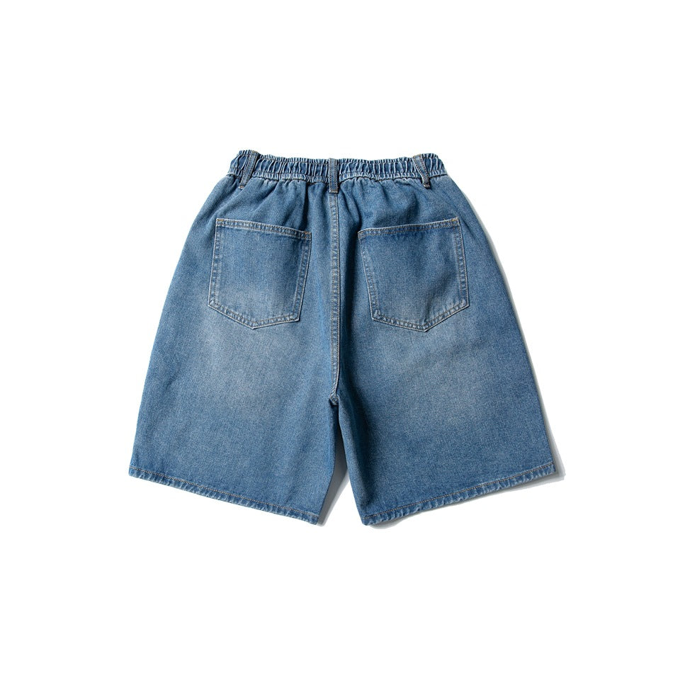Back view of blue washed denim shorts with two patch pockets and elastic waistband